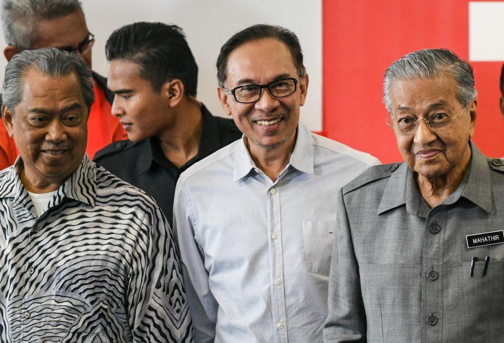 Pengerusi Pakatan Harapan Anwar Ibrahim (tengah) bersama dua bekas perdana menteri Muhyiddin Yassin (kiri) dan Mahathir Mohamad (kanan). Gambar: AFP