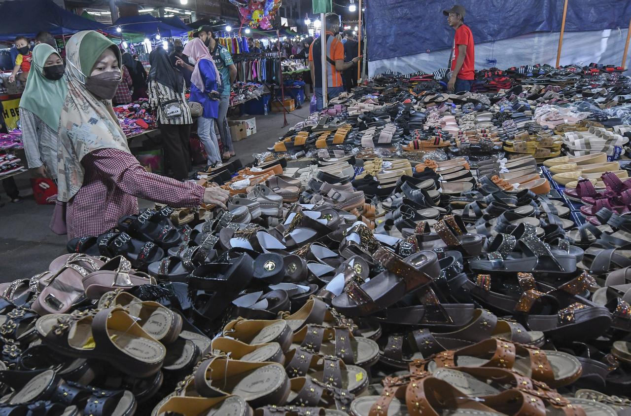 A woman looks through an array of shoes and slippers at a stall in the Syawal Buluh Kubu bazaar in Kota Bharu, ahead of Hari Raya celebrations next week. Photo: Bernama