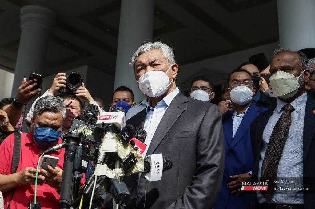 Umno president Ahmad Zahid Hamidi speaks to reporters outside the Kuala Lumpur High Court in January after being told to enter his defence for 47 charges of criminal breach of trust, corruption and money laundering.