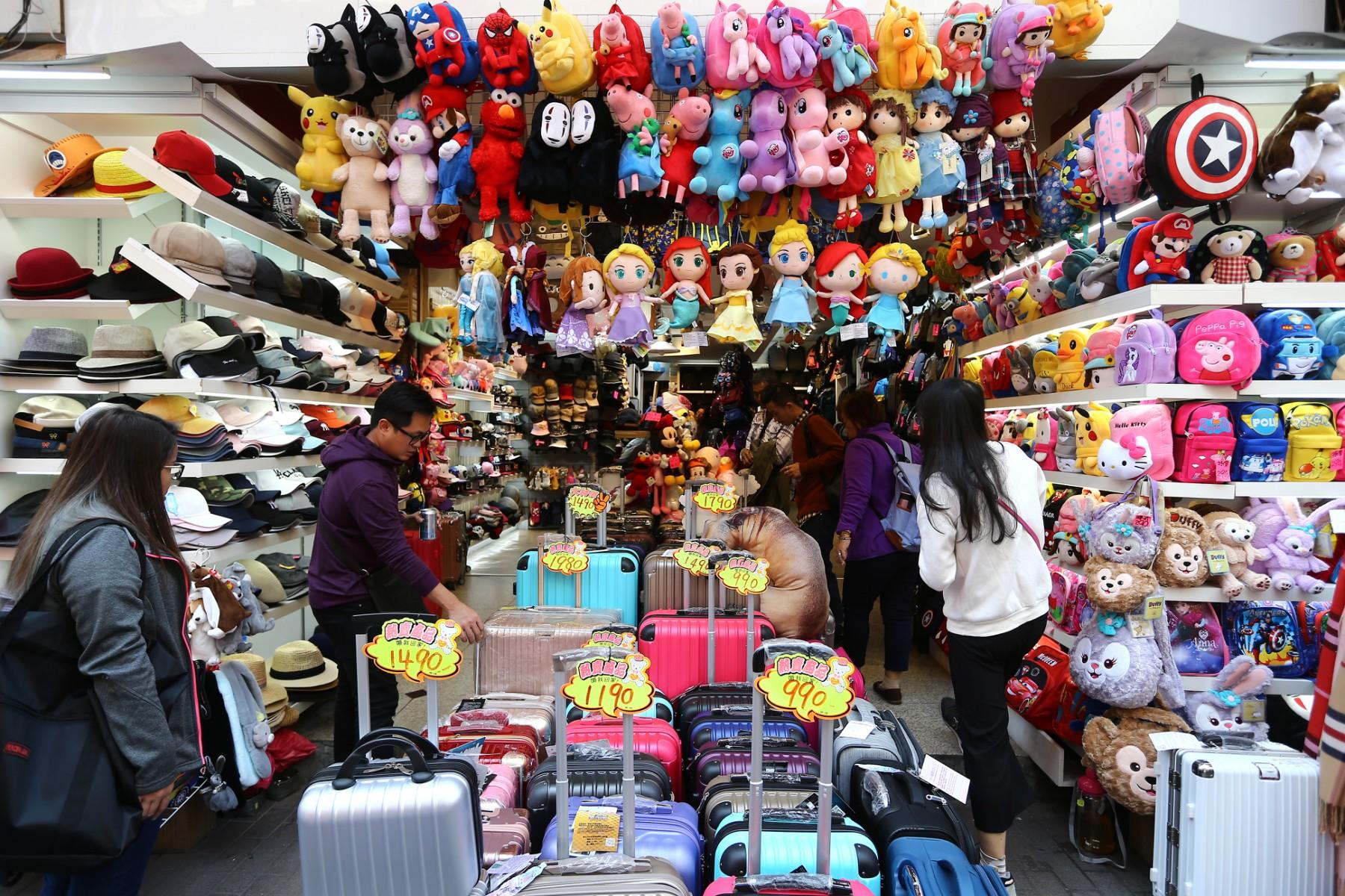 Shoppers take a look at various travel cases and cartoon backpacks in Taipei on March 12, 2018. Photo: AFP