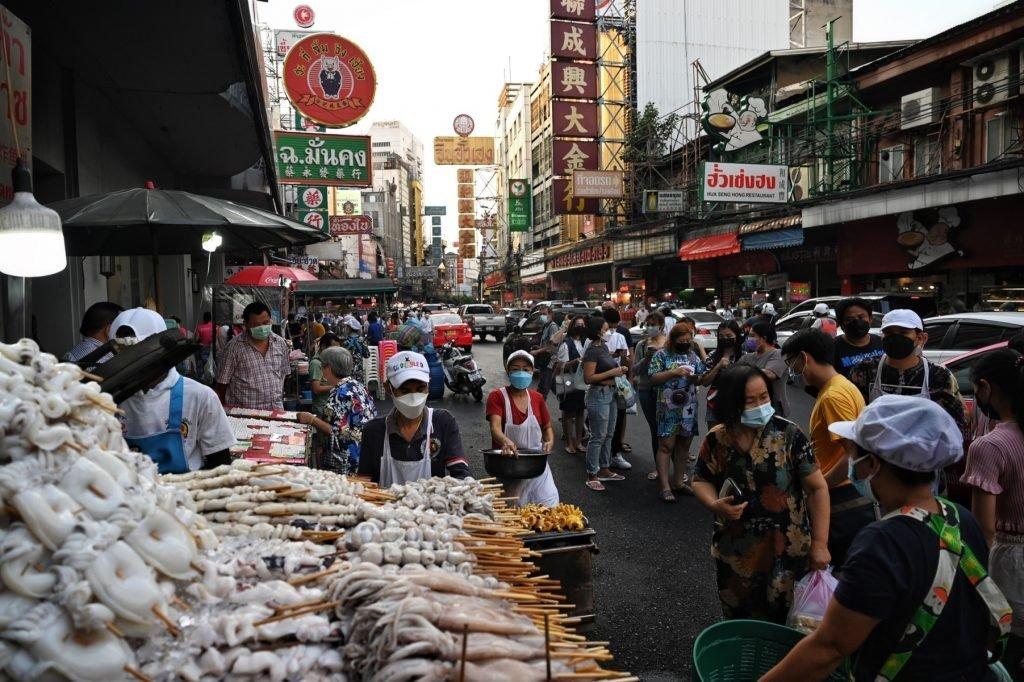 In this photo taken on Jan 16, people queue up for grilled seafood sticks in the Chinatown area of Bangkok. Thailand aims to attract five million to 10 million visitors this year, but critics call its Thailand Pass system an unnecessary obstacle. Photo: AFP
