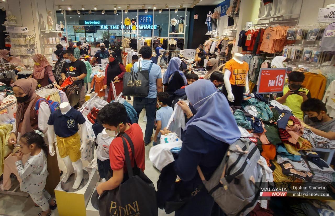 Shoppers look through racks of clothes at a mall in Kuala Lumpur ahead of Hari Raya Aidilfitri.