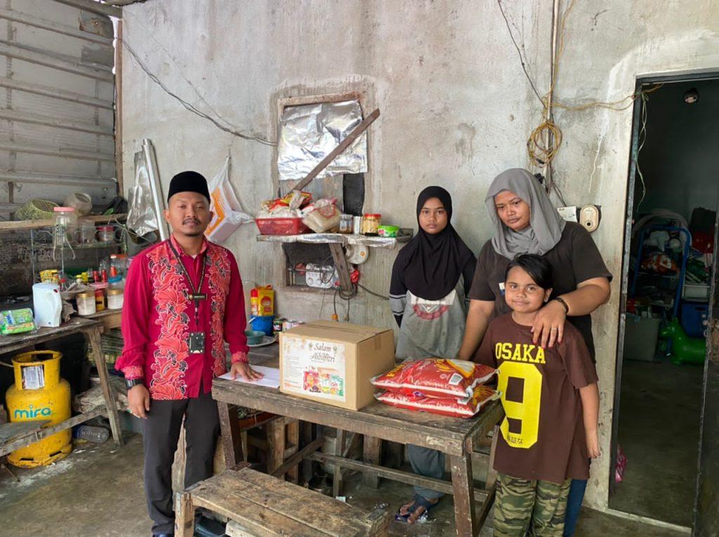 Hamidah and her daughters receive gifts of food items and basic necessities from the Perak Council of Islamic Religion and Malay Customs.