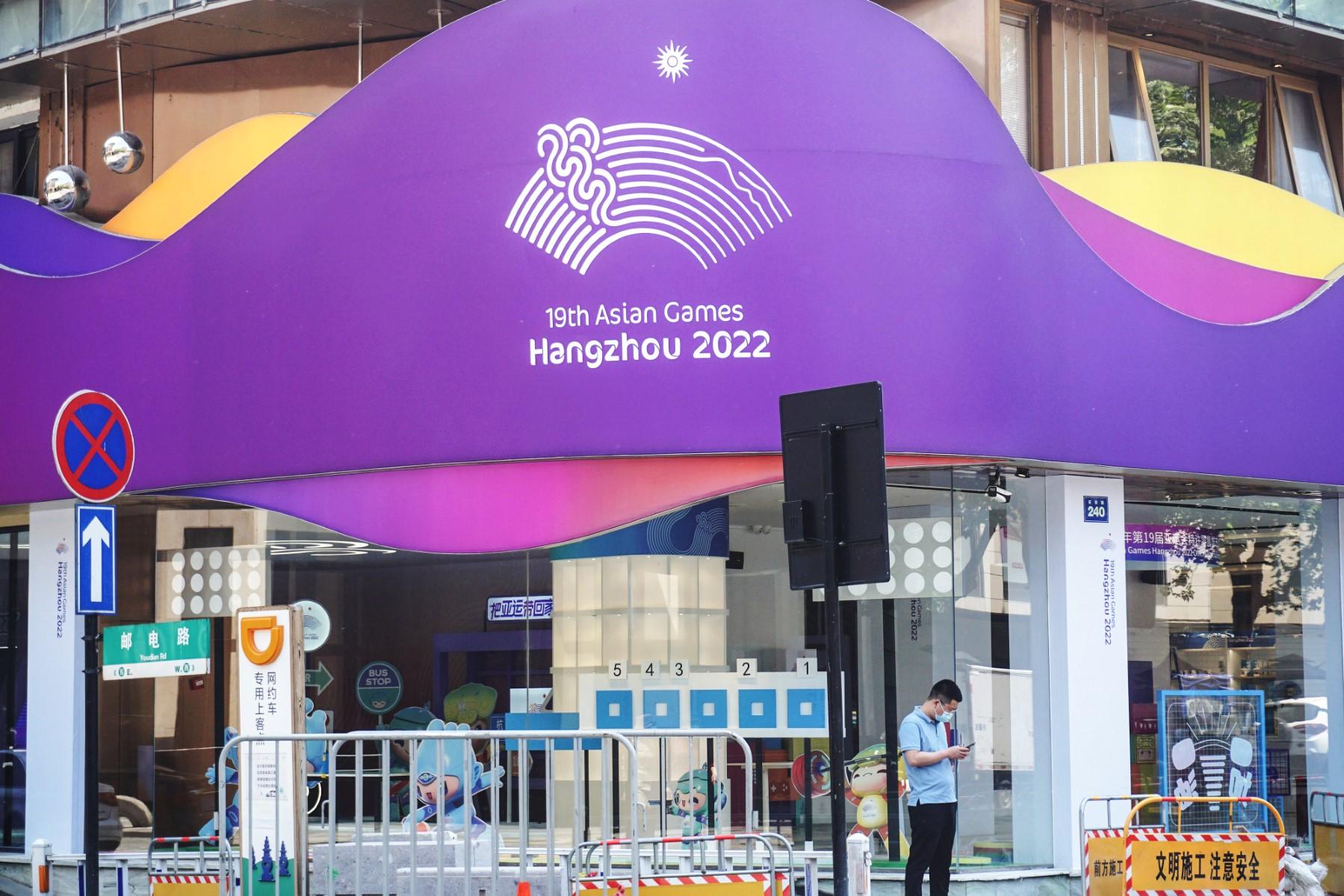 A man checks his phone outside a souvenir store for the 2022 Asian Games in Hangzhou, in China's eastern Zhejiang province on May 6. Photo: AFP