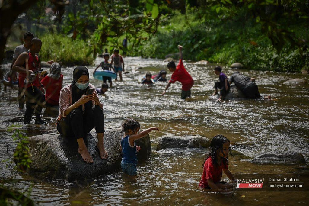 Families enjoy a dip in the river at Sungai Congkak in Hulu Langat, Selangor.