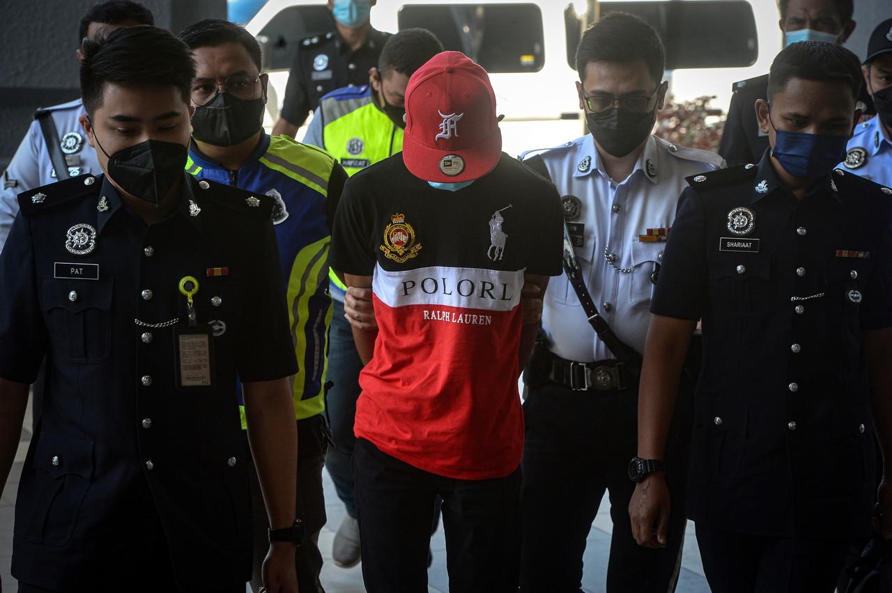 Erdy Errwan Hamdan is escorted by security officers at the Kuala Lumpur court complex today. Photo: Bernama