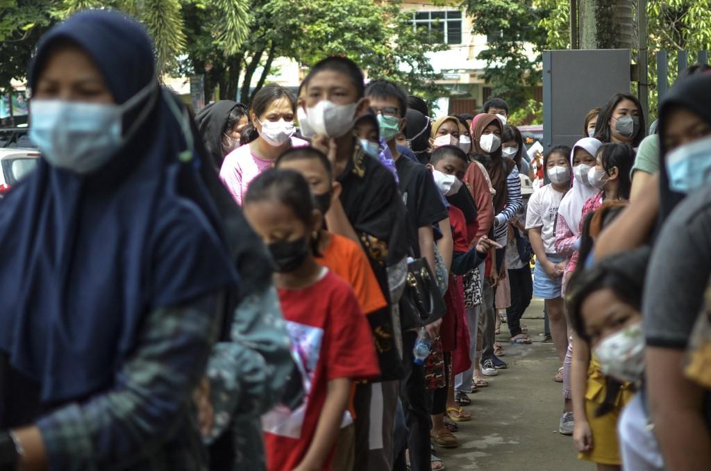 Parents accompany their children to be vaccinated against Covid-19 in Palembang, South Sumatra on Jan 9, 2021. Three children in Indonesia have died from acute hepatitis of unknown origin. Photo: AFP