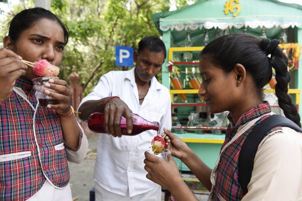 Schoolgirls enjoy an ice popsicle during a hot summer day in Amritsar on April 28. Photo: AFP
