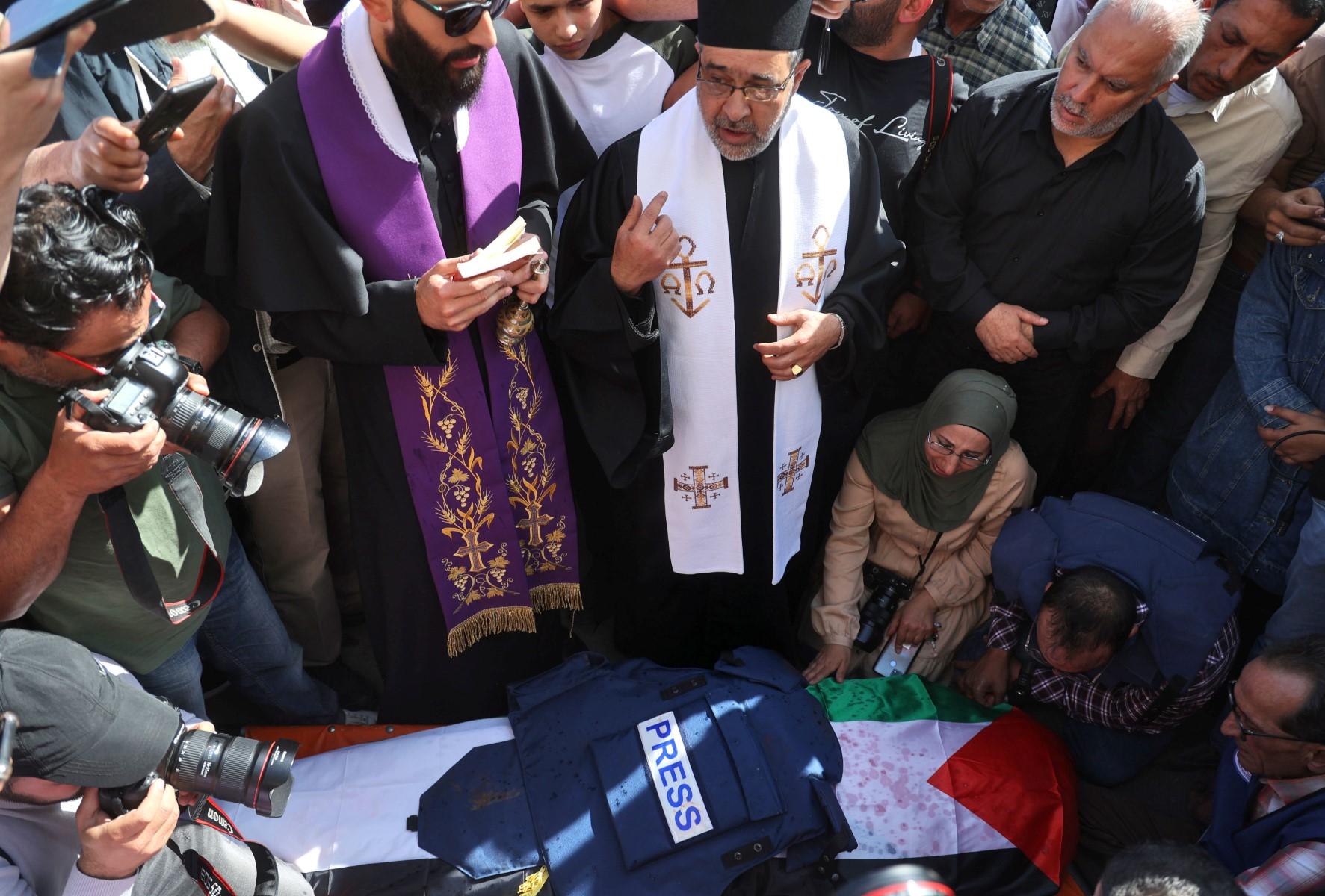 Priests, friends and relatives mourn over the body of veteran Al Jazeera journalist Shireen Abu Aqleh, who was shot dead by Israeli troops as she covered a raid on the West Bank's Jenin refugee camp, on May 11. Photo: AFP