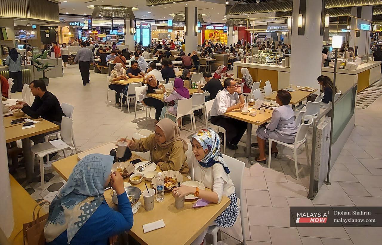 Customers chat as they enjoy a meal at a food court in Bukit Bintang, Kuala Lumpur.