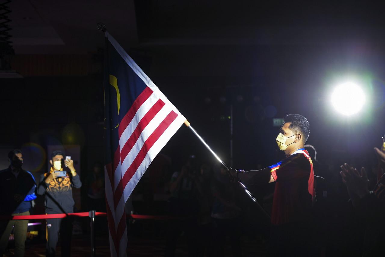 The Malaysian flag is carried in at the handover ceremony to the Malaysian contingent to the Hanoi SEA Games at the National Sports Council on April 27. Photo: Bernama