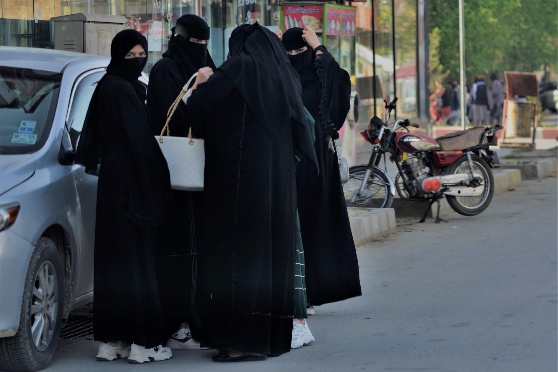 Women wearing Niqab garments stand along a street in Kabul on May 7. Photo: AFP