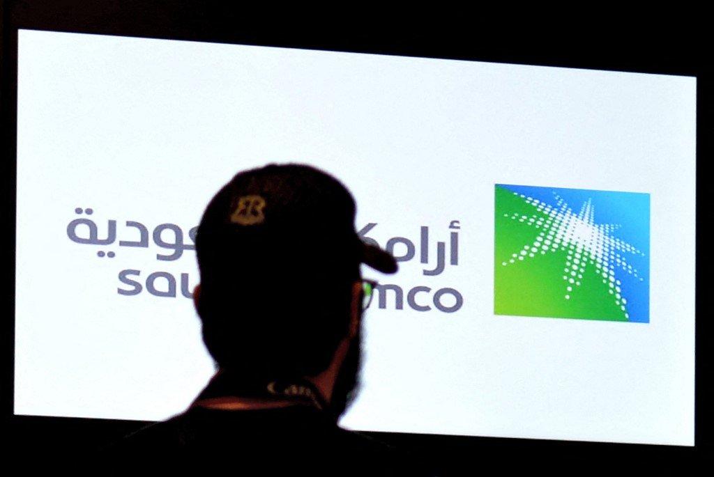 Seorang lelaki melihat papan bursa di Riyadh memaparkan saham Aramco pada hari kedua dagangan pada 12 Disember 2019. Gambar: AFP