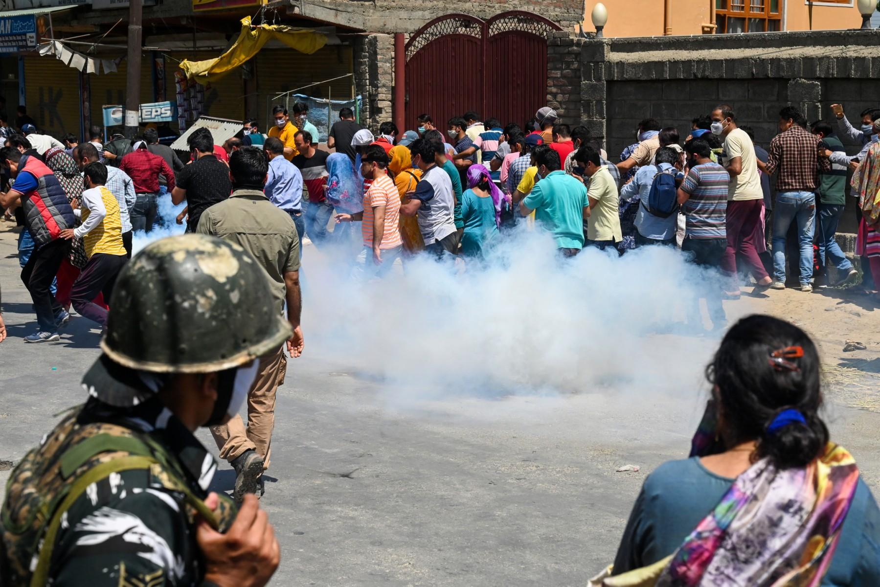 Police fire tear gas to disperse demonstrators marching toward the governor's house to protest against the killing of a government employee belonging to the Kashmiri Pandit community on the outskirts of Srinagar on May 13. Photo: AFP