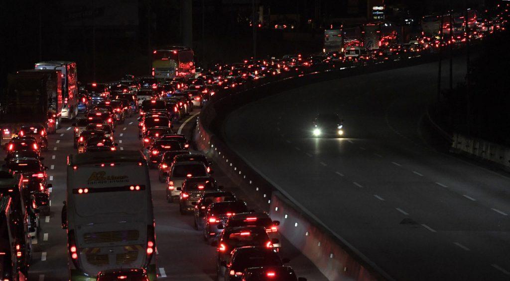 Lampu merah kereta mewarnai kegelapan kesesakan trafik di lebuh raya setiap kali musim perayaan. Hijrah pulang ke kampung, mungkin dapat menjadi solusi isu yang terus berlarutan dalam negara. Gambar: Bernama
