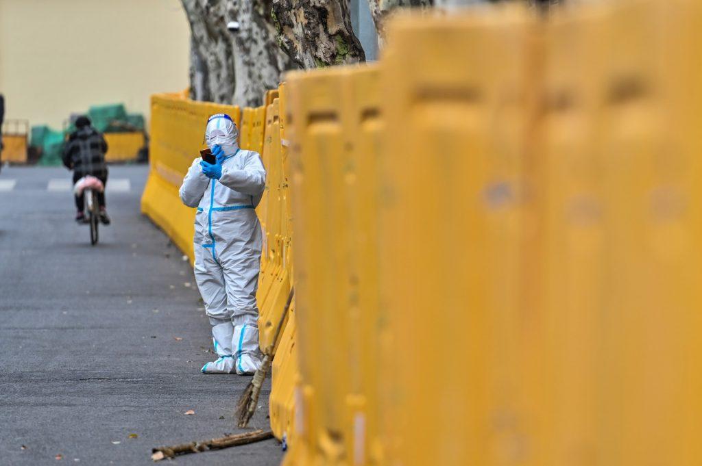 In this file photo taken on March 31 a worker wearing a protective gear, stands next to barriers during lockdown as a measure against Covid-19 in Jing'an district, in Shanghai on March 31. Photo: AFP