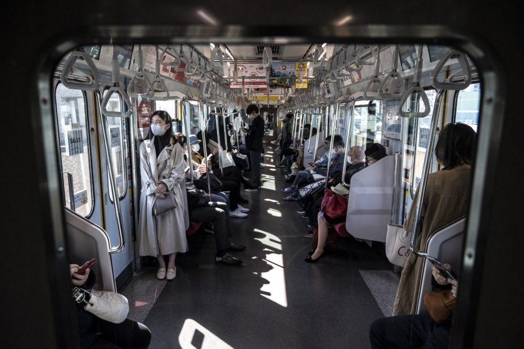 Penumpang tren di Tokyo memakai pelitup muka bagi mengelak jangkitan wabak Covid-19. Gambar: AFP