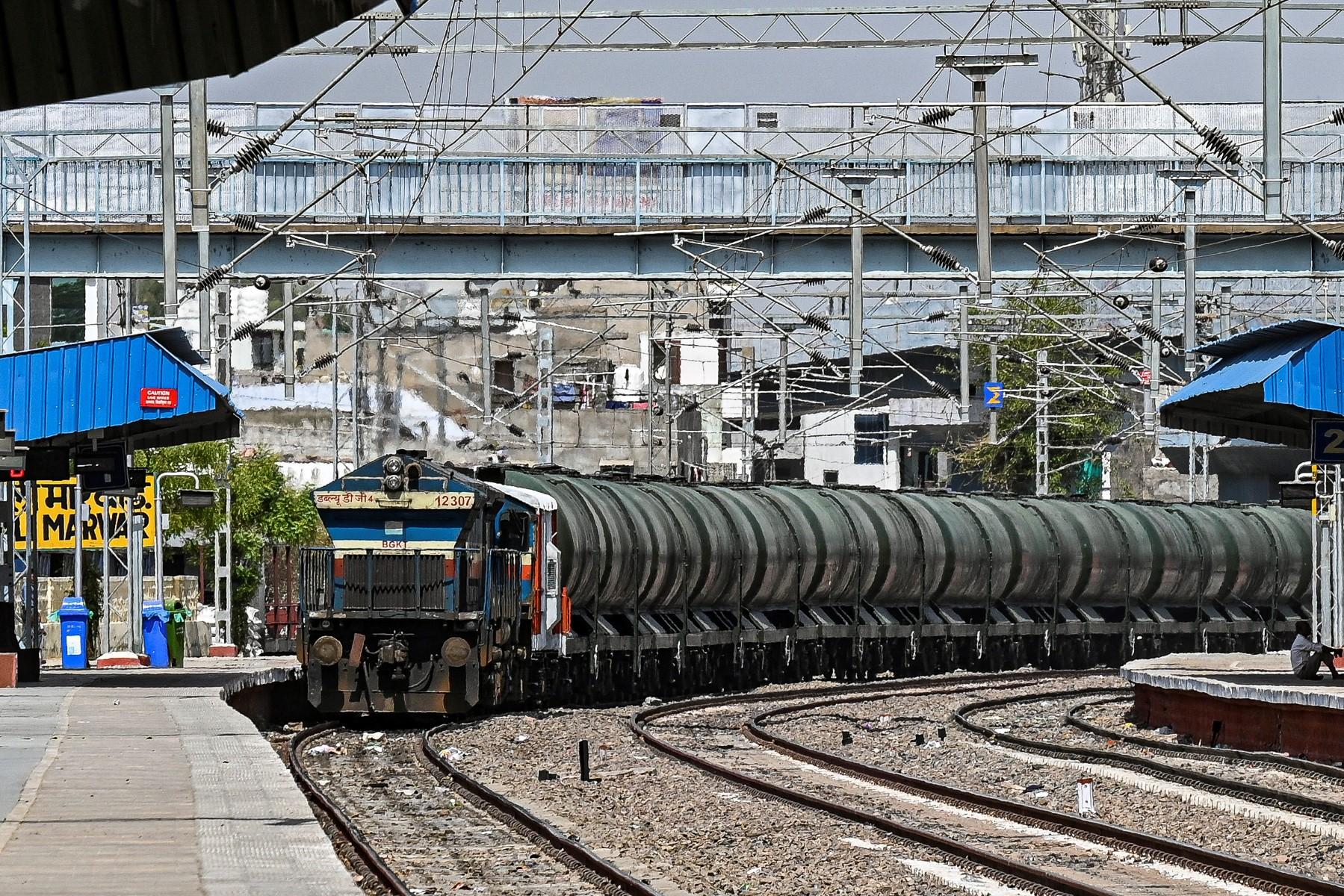 This photograph taken on May 11, shows a man sitting near a special train carrying water for storage in the underground tanks for the usage by people on a hot summer day in Pali.  Photo: AFP