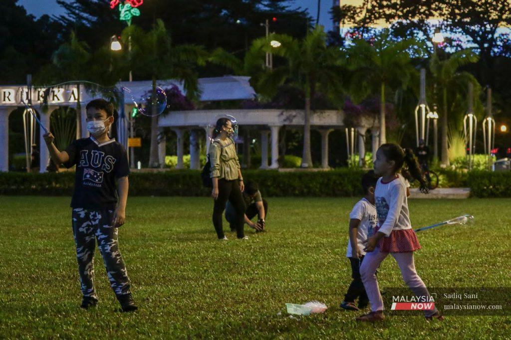 Kanak-kanak bermain di Dataran Merdeka, Kuala Lumpur bersama keluarga.
