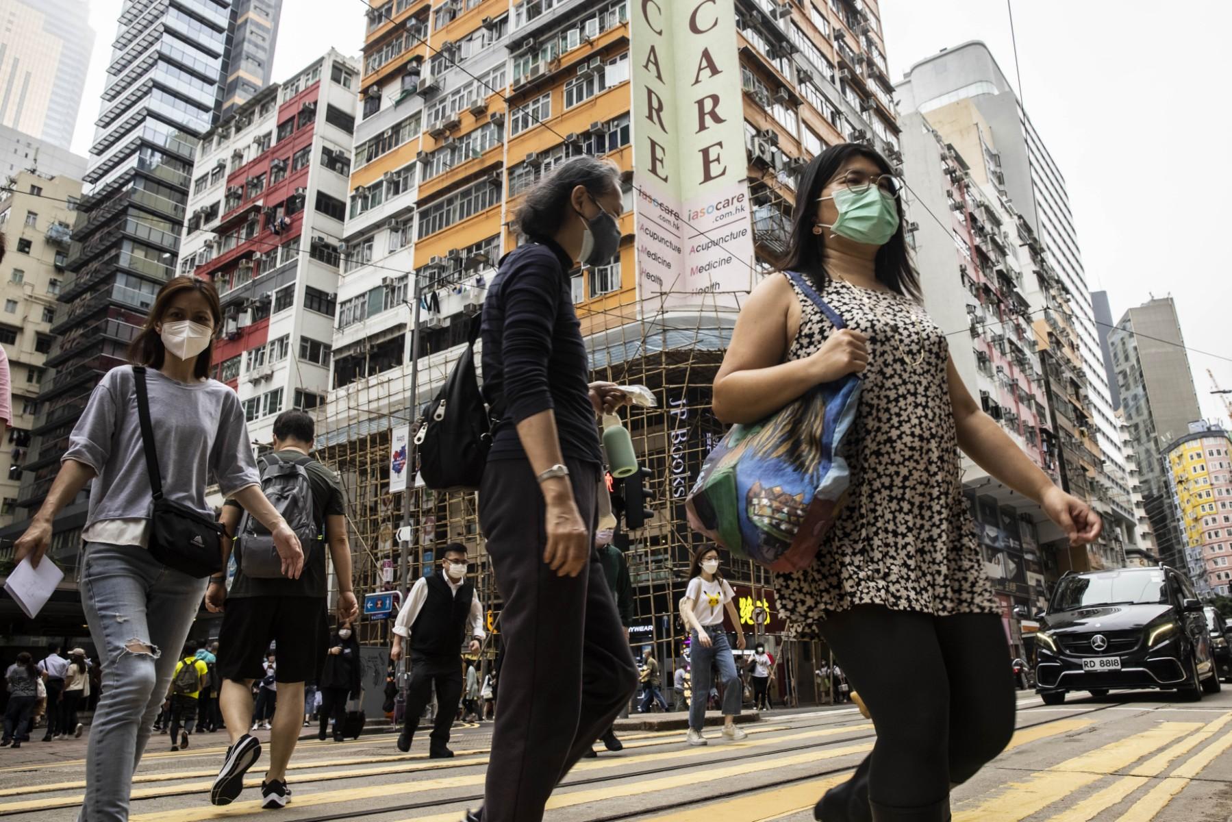People cross a street in Hong Kong in this May 13 photo. Hong Kong has imposed strict social distancing rules as its hews to a lighter version of China's zero-Covid strategy. Photo: AFP