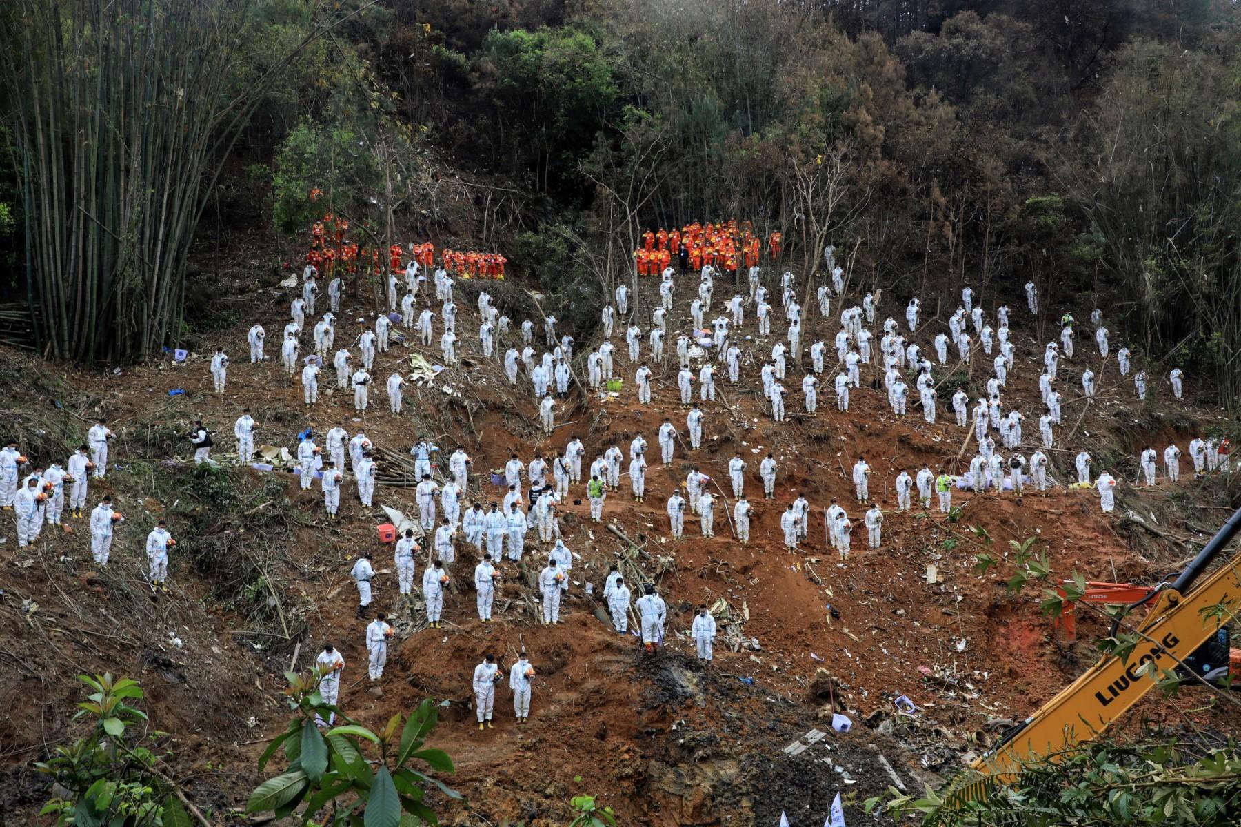 This photo taken on March 27 shows rescuers standing in a silent tribute for victims at the site of the China Eastern Airlines plane crash in Tengxian, Wuzhou, in China's southern Guangxi region. The Boeing 737-800 was flying between the cities of Kunming and Guangzhou on March 21 when it nosedived into a mountainside, disintegrating on impact and killing all 132 people on board. Photo: AFP