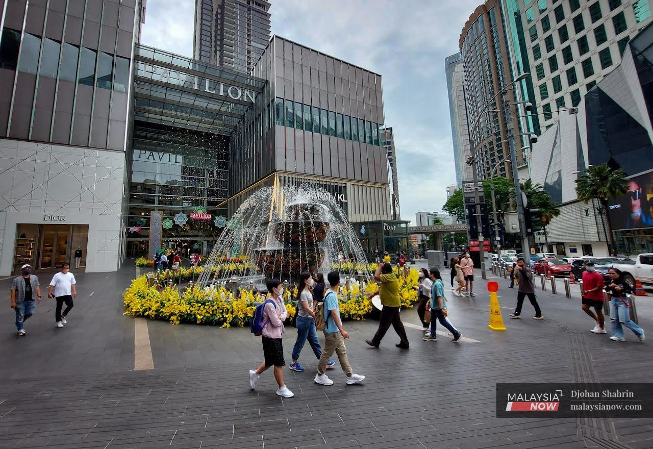 Pengunjung berjalan di ruang legar Pavillion di Kuala Lumpur dengan memakai pelitup muka, orang ramai masih lagi mengekalkan garis panduan Majlis Keselamatan Negara walaupun kelonggaran sekatan telah diumumkan sejak 1 April lalu.
