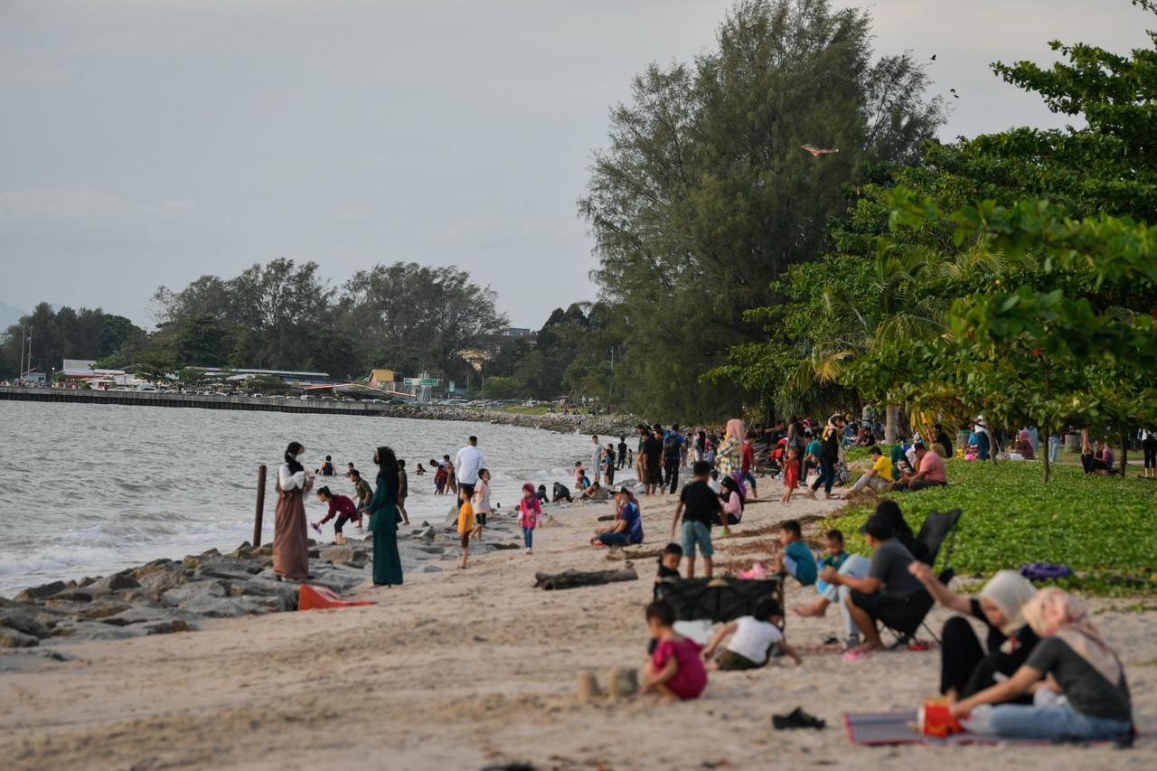 Families spend a day at the beach at Pantai Bagan Ajam in Butterworth. Photo: Bernama