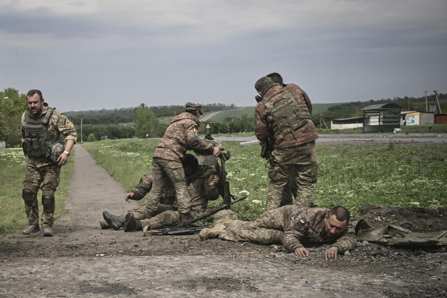 Ukrainian servicemen assist their comrades not far from the frontline in the eastern Ukrainian region of Donbas, on May 21. Photo: AFP