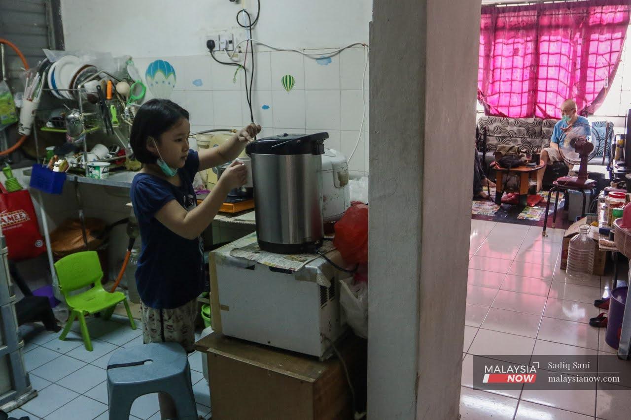 Suki Wong Pei Yee menyiapkan minuman kepada bapanya yang separa lumpuh akibat strok.