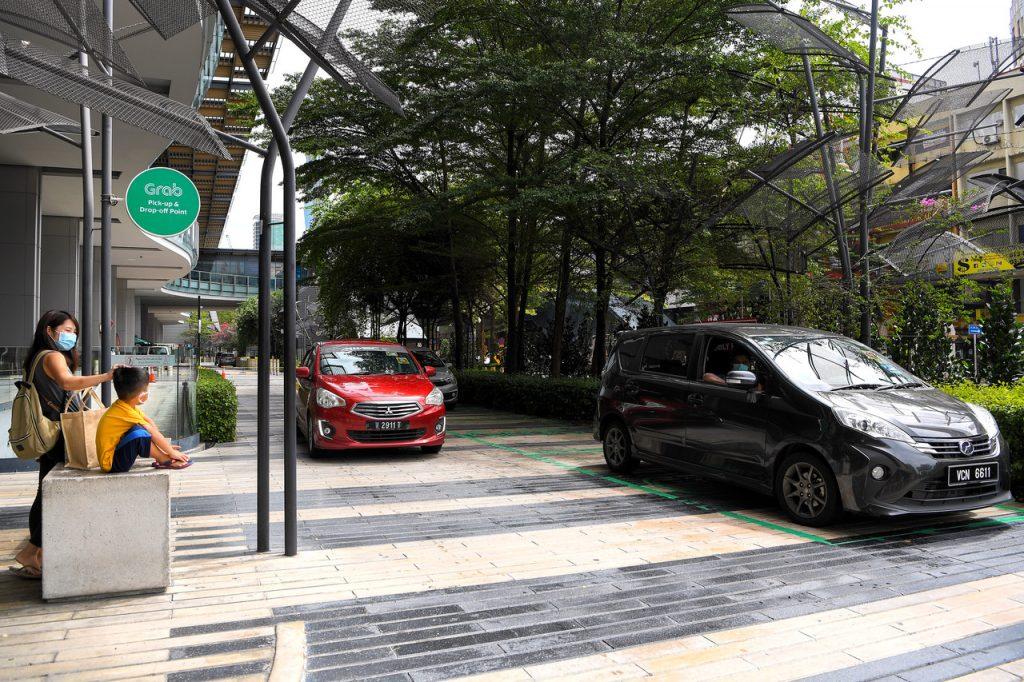 Penumpang kereta perkhidmatan e-hailing Grab menunggu kereta di Jalan Brickfields, Kuala Lumpur. Gambar: Bernama