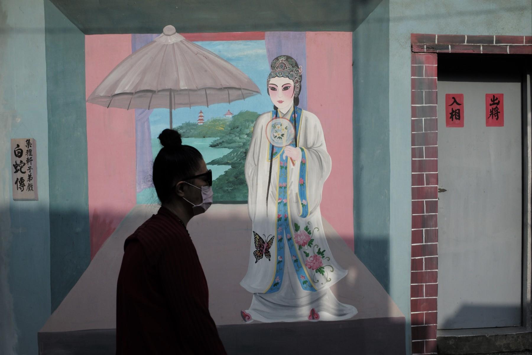 A man walks past a painted wall showing the 'Legend of the White Snake' in Beigang township in Chiayi county on May 21. Taiwan is excluded from most global groups due to Beijing's objections. Photo: AFP