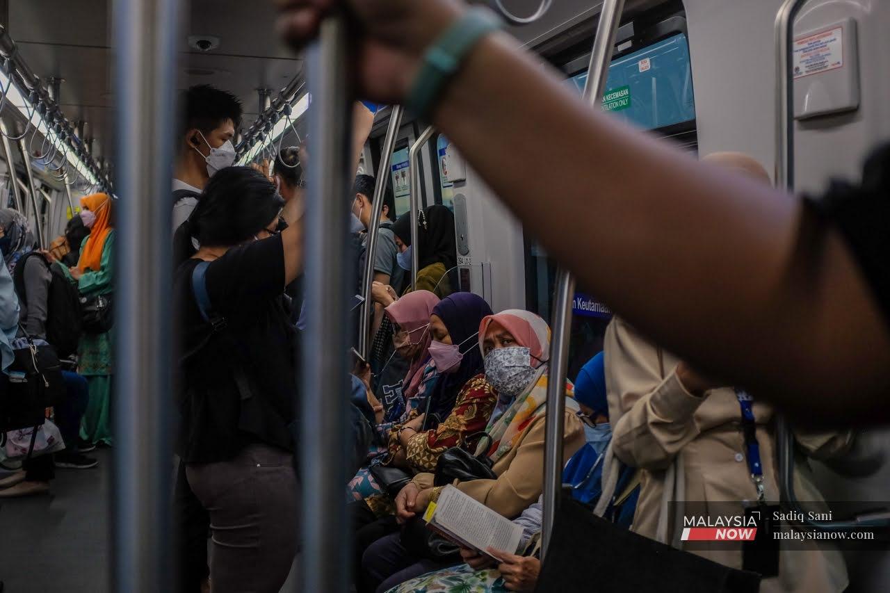 Commuters wearing face masks to curb the spread of Covid-19 take the LRT home from work in Kuala Lumpur.