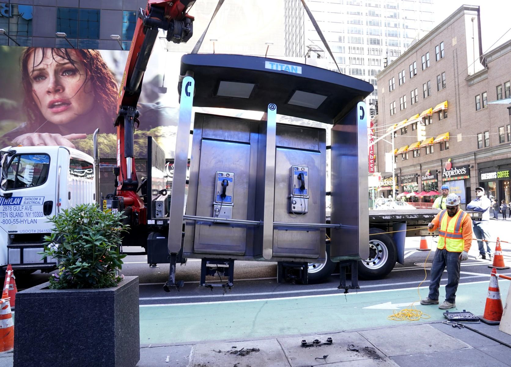 Workers remove the final New York City payphone near Seventh Avenue and 50th Street in Midtown Manhattan, New York City, on May 23. Photo: AFP