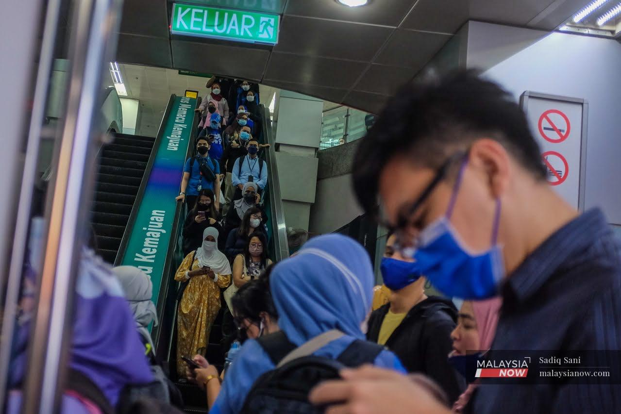 Commuters wearing face masks fill the KLCC LRT station in Kuala Lumpur as the work day ends and rush hour begins.