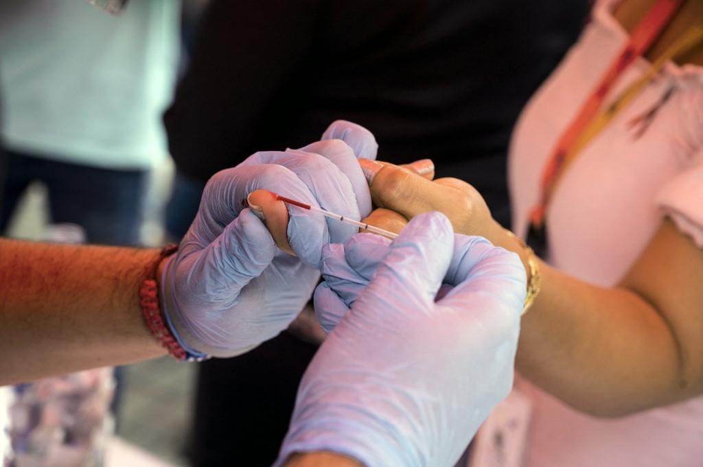 A health worker takes a blood sample to perform a rapid HIV test in this Dec 3, 2021 file picture. Photo: AFP