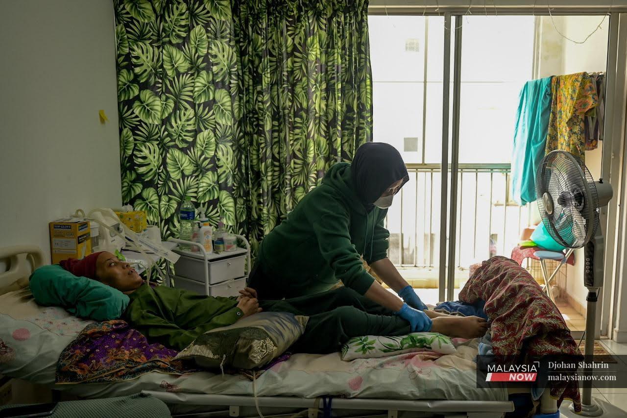Fifteen-year-old Hilda tends to her mother, Norhasnita Nordin, at their home in Pantai Dalam, Kuala Lumpur.