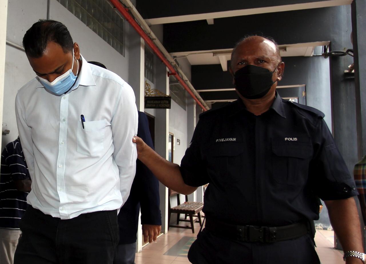 Insurance agent T Vengadasalabathi escorted by security personnel at the Ipoh Sessions Court today. Photo: Bernama