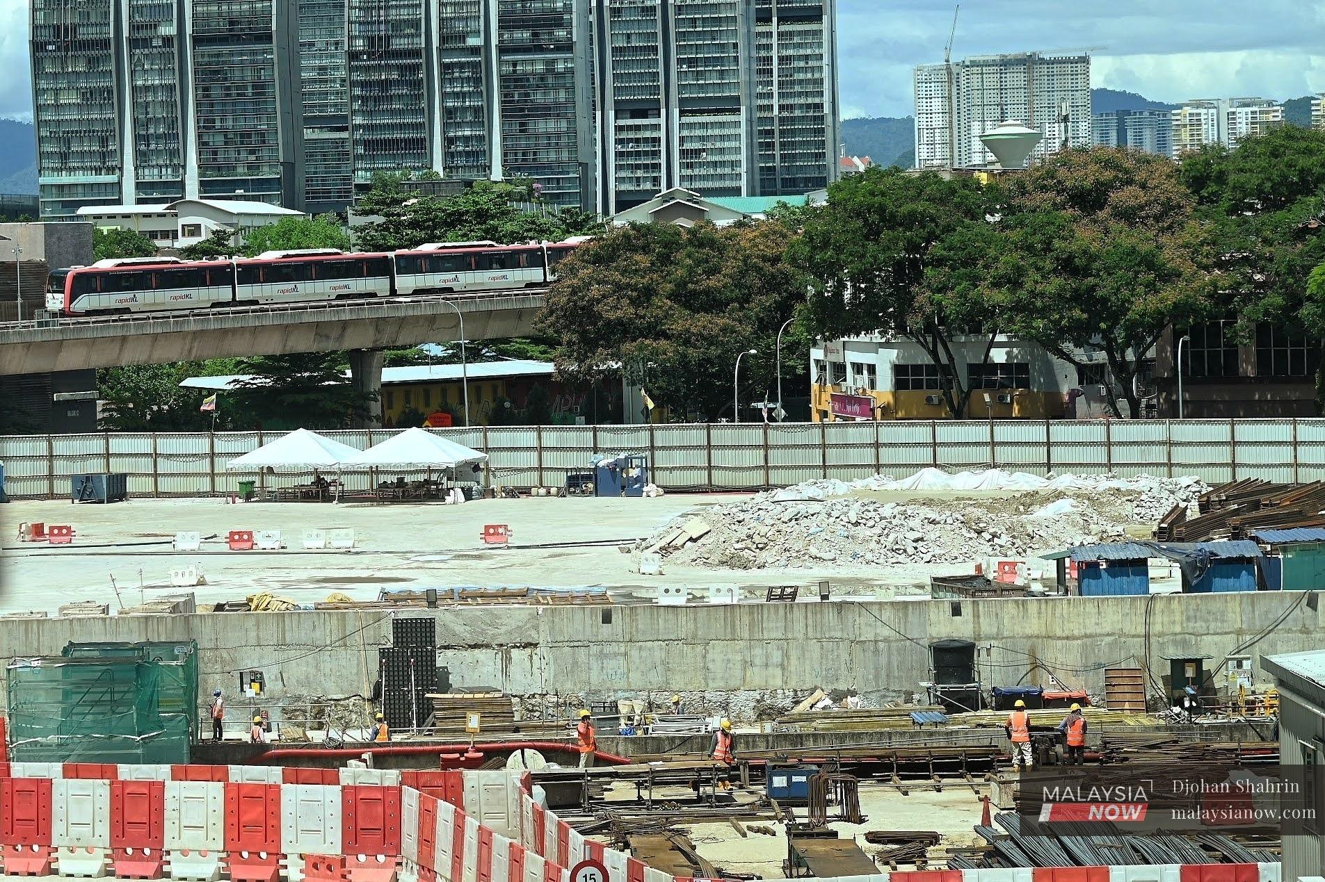 Workers carry out their duties at the construction site of the MRT2 Titiwangsa station in this November 2020 file picture.