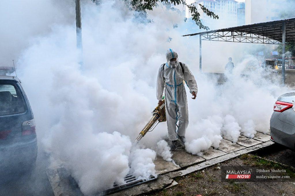 Sukarelawan menyembur pembasmi nyamuk Aedes di kawasan flat PPR Pudu Ulu, Kuala Lumpur.