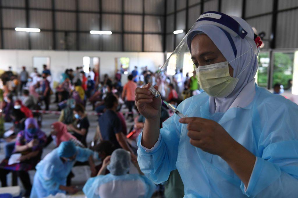 A nurse in Sabah prepares a syringe of Covid-19 vaccine to be administered during an outreach programme to a village in Kota Kinabalu. Photo: Bernama