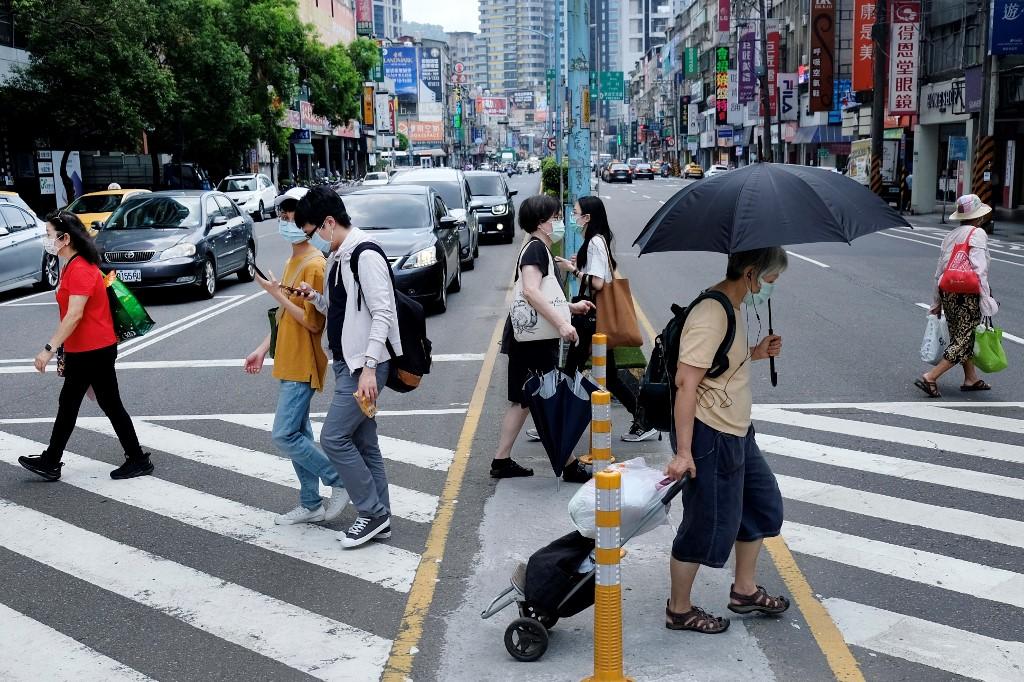 Pedestrians cross a street in New Taipei City on May 15, 2021. Photo: AFP