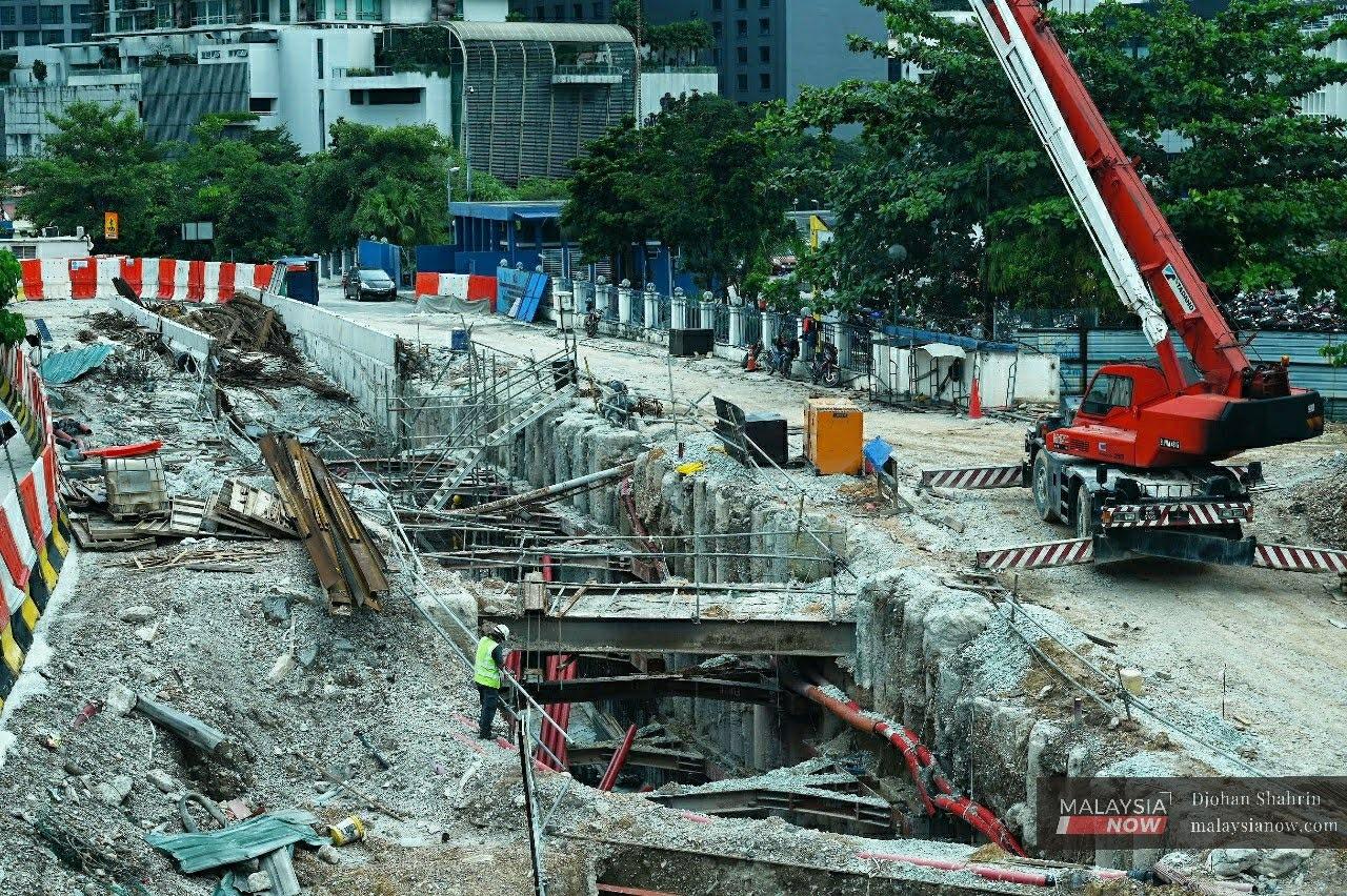 Construction workers carry out their duties at the project site of an MRT2 station in Kuala Lumpur, in this November 2020 file photo.