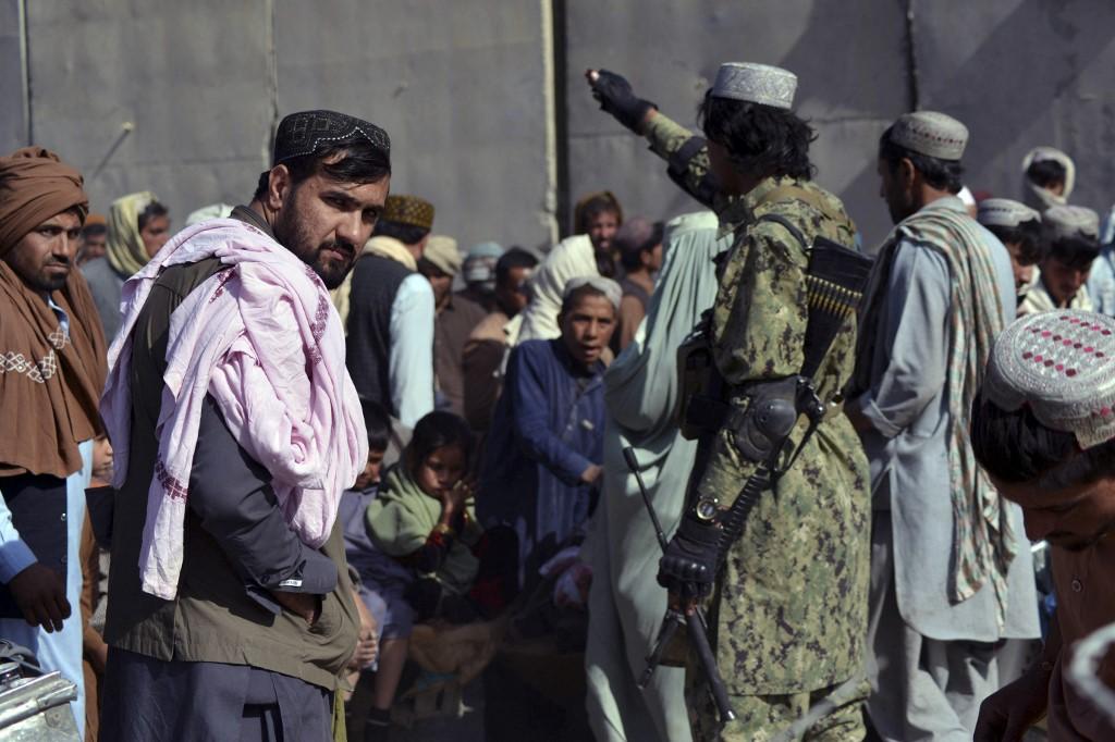 A Taliban fighter (right) gestures to people waiting to cross into Pakistan at the Afghanistan-Pakistan border crossing point in Spin Boldak on Nov 3, 2021. Photo: AFP