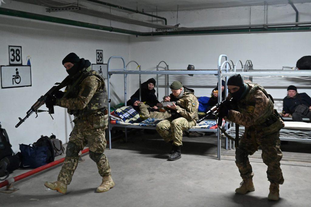 A soldier of the Territorial Defense Forces of Ukraine, the military reserve of the Armed Forces of Ukraine, eats his lunch while others training in an underground garage that has been converted into a training and logistics base in Kyiv, on March 11. Photo: AFP