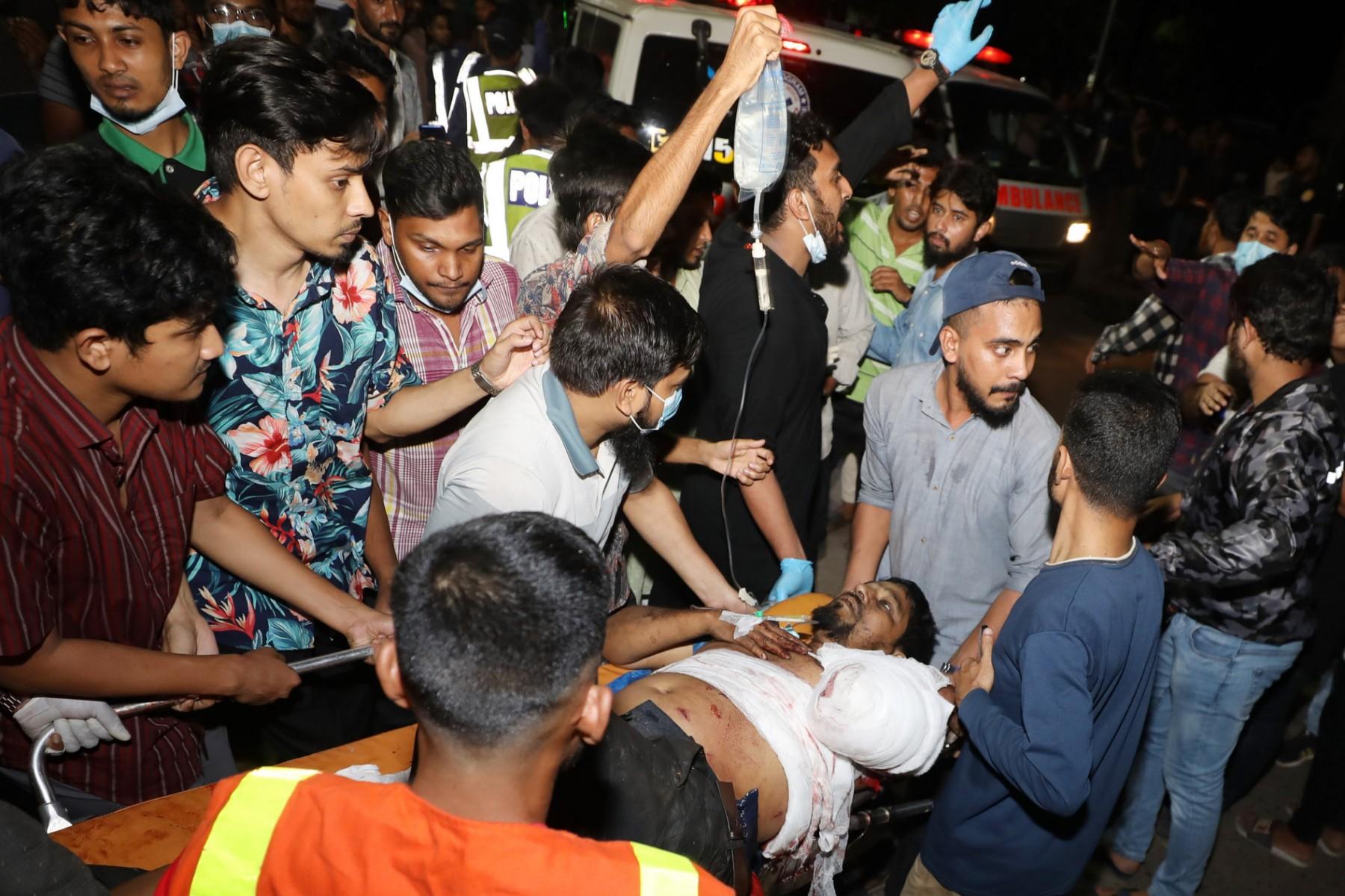 Rescue workers and civilians carry an injured victim to a hospital in Chittagong, after a fire broke out at a container storage facility in Chittagong, on June 5. Photo: AFP