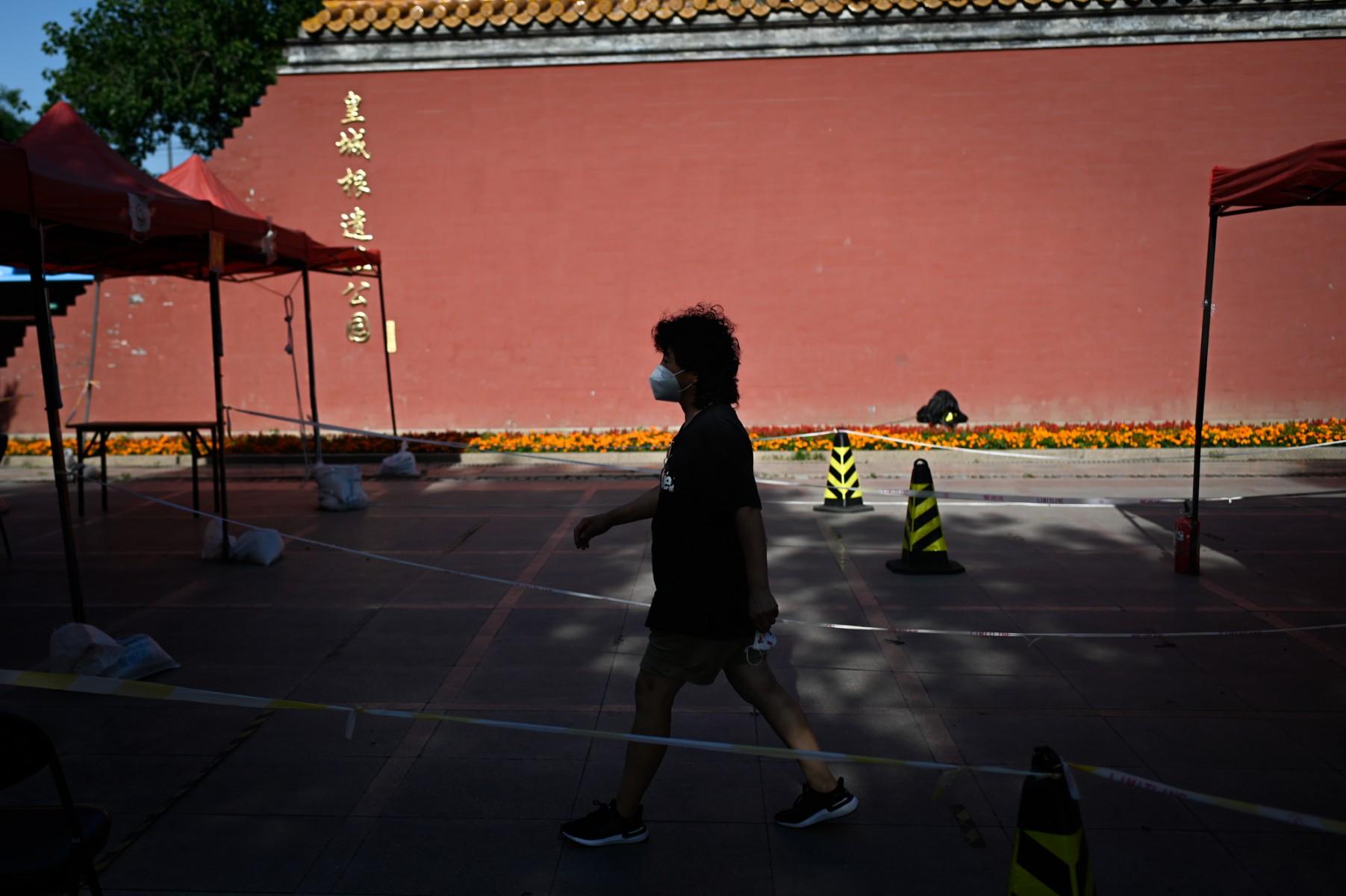 A woman walks near a Covid-19 swab testing site in Beijing on June 1. Photo: AFP