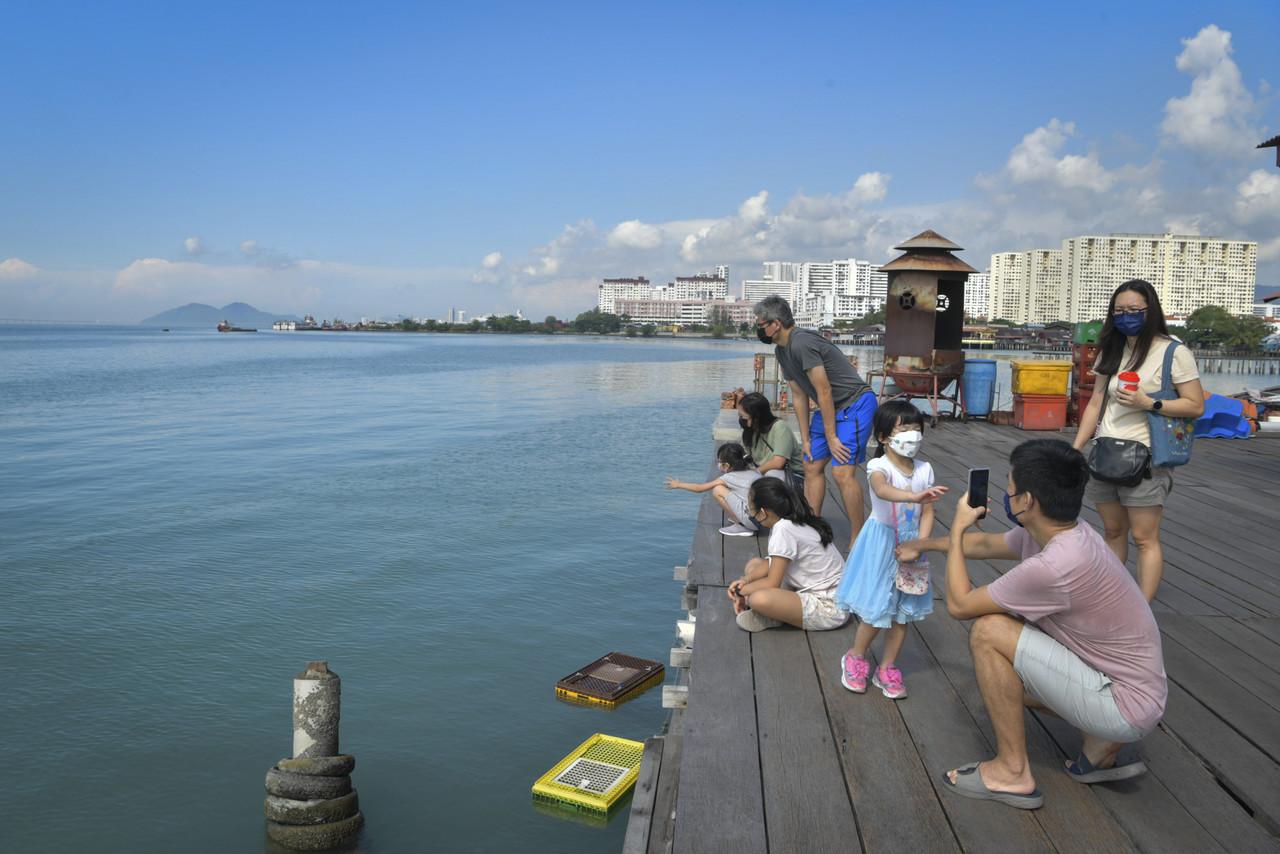 Families spend a day out at Chew Jetty in George Town, Penang. Photo: Bernama