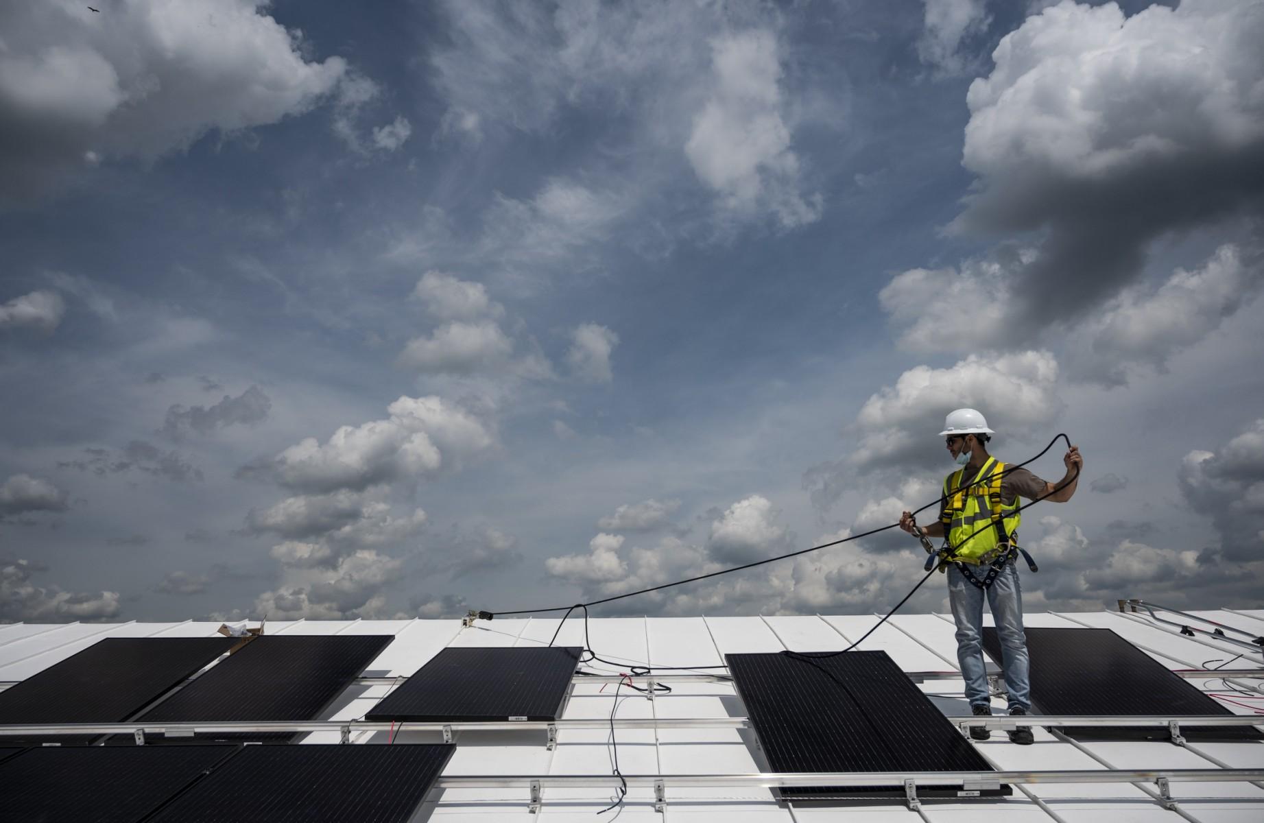 A worker installs solar panels on the roof of a church in Alexandria, Virginia on May 17, 2021. Manufacturing makes up a small portion of the US solar industry, with most of the jobs concentrated in project development, installation and construction. Photo: AFP