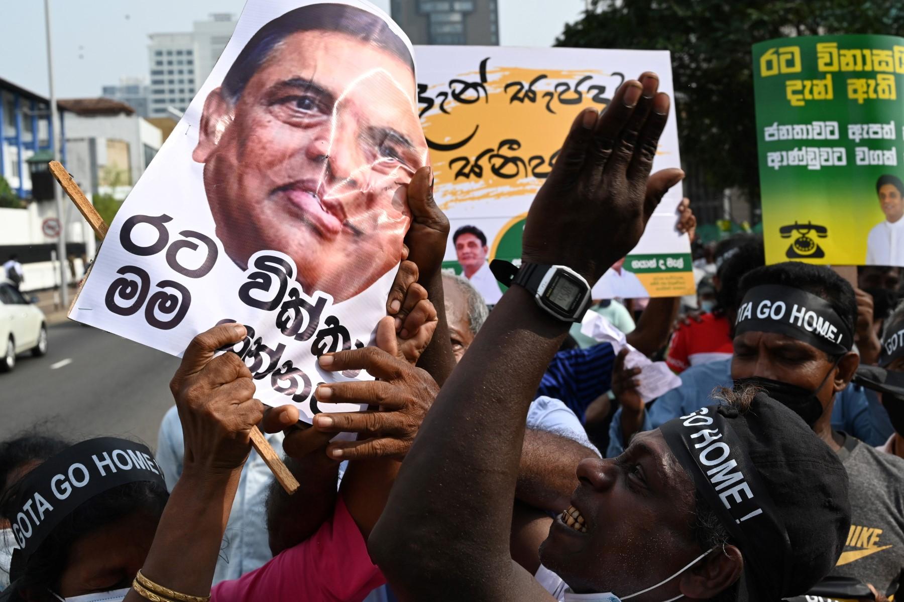 An opposition activist holds a placard depicting former Sri Lanka finance minister Basil Rajapaksa during a protest against rising living costs, at the entrance of the president's office in Colombo on March 15. Photo: AFP