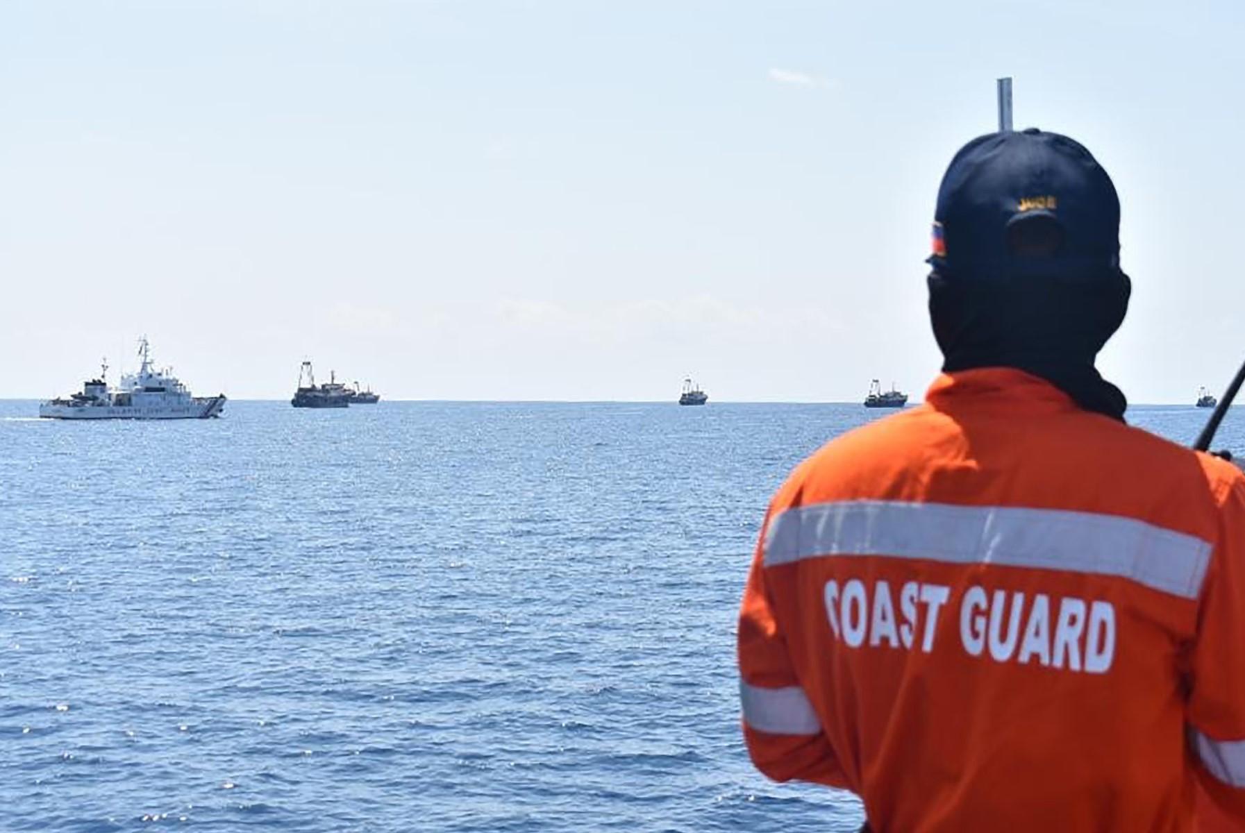 This handout photo taken on April 27, 2021 and received from the Philippine Coastguard on May 5, 2021 shows Philippine coastguard personnel monitoring Chinese vessels (right) at Sabina Shoal, a South China Sea outcrop claimed by Manila. Photo: AFP